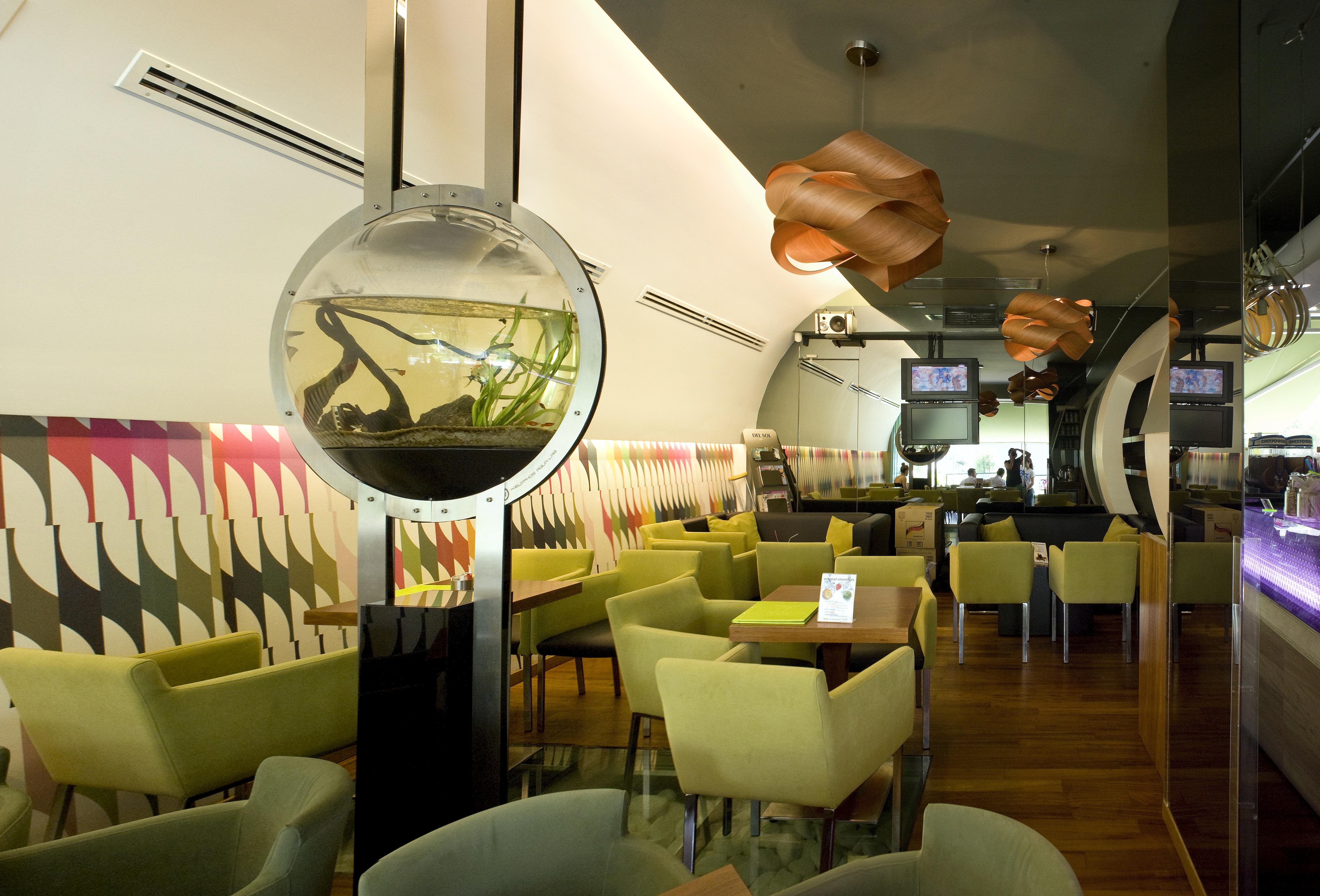 Cafe Del Sol interior with olive seating and a circular aquarium