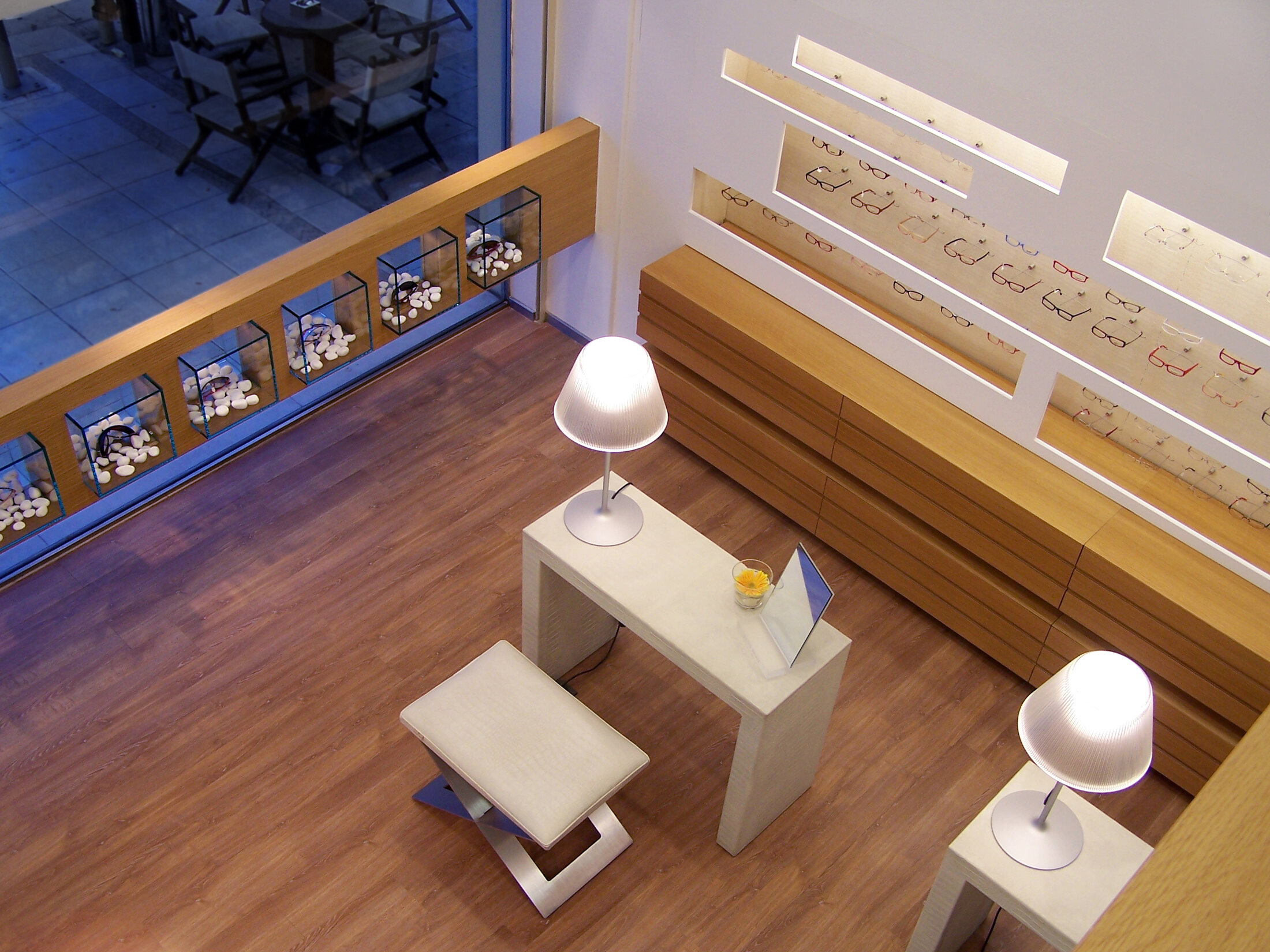 Tsipourakis optical store with warm timber and illuminated displays